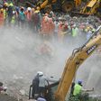 Rescue workers search for survivors in the rubble of the collapsed five-storey apartment building in Mahad