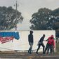 Young men haul a burning tyre during protests at Tygerberg Raceway near Cape Town. The motor-racing venue was invaded on August 6 by people demanding land