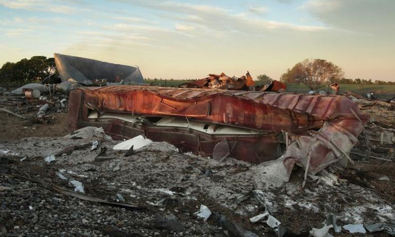 A railroad boxcar filled with ammonium nitrate lays on its side near to the remains of the fertilizer plant that exploded on April 18, 2013 in West, Texas