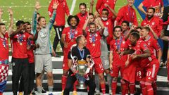 Bayern Munich players and coach Hansi Flick celebrate with the trophy after beating PSG in Sunday's Champions League final in Lisbon