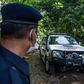 A member of the Royal Malaysia Police stands guard as a forensic vehicle leaves the main entrance of the location where Nora Quoirin's body was found