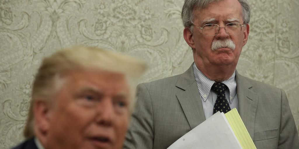 U.S. President Donald Trump speaks to members of the media as National Security Adviser John Bolton listens during a meeting with President of Romania Klaus Iohannis in the Oval Office of the White House August 20, 2019 in Washington, DC.