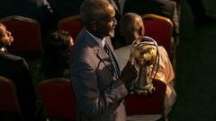 Stephen Tataw carries the trophy of the African Championship of Nations (CHAN) to the stage during the draw ceremony in Yaounde in February