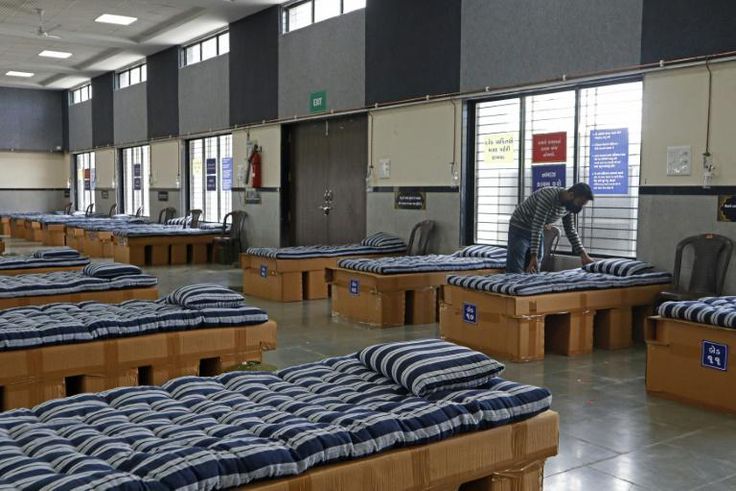 A man adjusts a bed inside the office of Indian businessman Kadar Shaikh, who converted his business premises into a cornavirus ward for the poor after recovering from the illness
