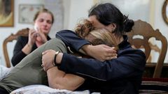 (L to R) Rita Hitti (mother of 27-year-old missing fireman Najib) and her daughter Carlyn (wife of 37-year-old missing fireman Charbel Karam) cry as they comfort each other at their home in the mountain town of Qartaba, north of the Lebanese capital