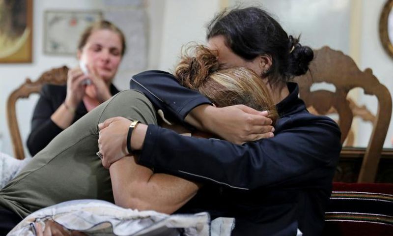 (L to R) Rita Hitti (mother of 27-year-old missing fireman Najib) and her daughter Carlyn (wife of 37-year-old missing fireman Charbel Karam) cry as they comfort each other at their home in the mountain town of Qartaba, north of the Lebanese capital