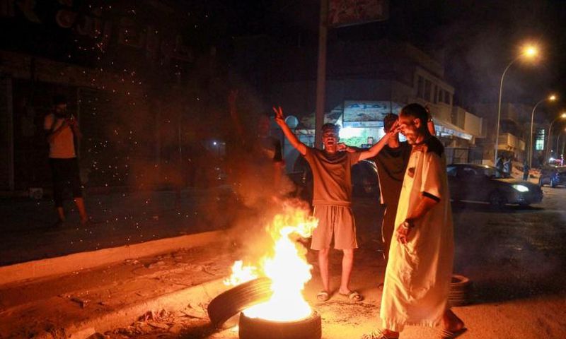 Libyan youth block a road with burning tyres in the eastern city of Benghazi to protest against poor public services and living conditions