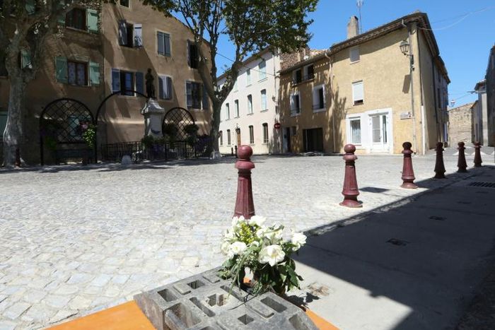 A bouquet of white roses lies at the top of the drain where the body was found