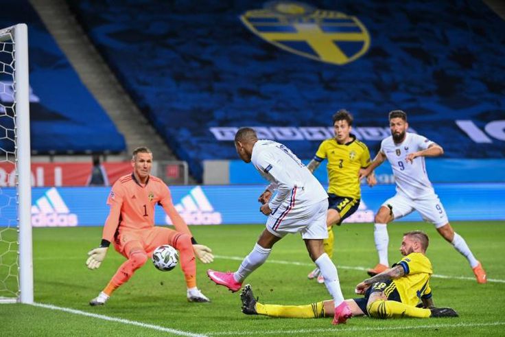 France's forward Kylian Mbappe (C) scores the opening goal past Sweden's goalkeeper Robin Olsen (L) during the UEFA Nations League football match between Sweden and France on September 5, 2020 at the Friends Arena in Solna, near Stockholm.
