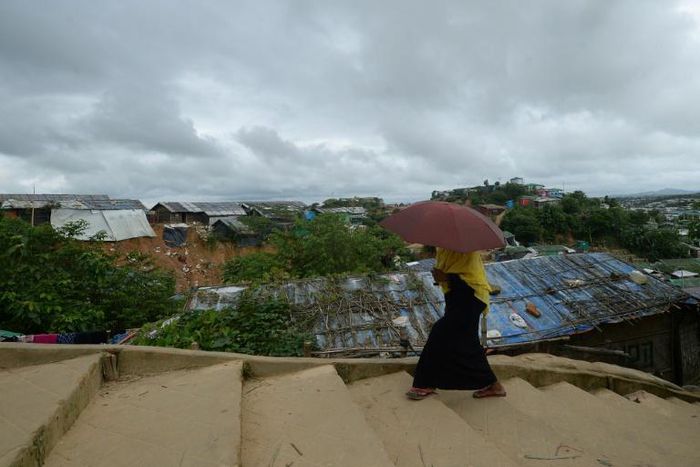 A Rohingya woman climbs a hill as she goes back to her makeshift home in Jamtoli refugee camp, near Ukhia in Bangladesh