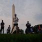 Members of  the Covid Memorial Project hold American flags in front of the Washington monument to commemorate the victims of the coronavirus
