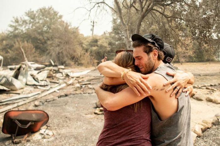 Resident Austin Giannuzzi cries while embracing family members at the burned remains of their home during the LNU Lightning Complex fire in Vacaville, California on August 23, 2020