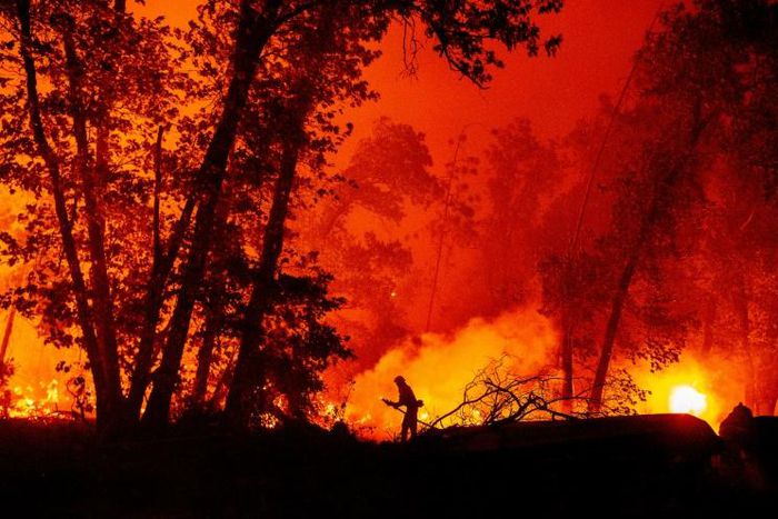 A firefighter douses flames as they push towards homes during the Creek Fire in the Cascadel Woods area of unincorporated Madera County, California on September 7, 2020