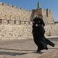 A priest, wearing a protective mask amid the Covid-19 pandemic, walks along the walls of Jerusalem's Old City on September 12, 2020