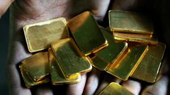 FILE PHOTO: A worker shows gold biscuits at a precious metals refinery in Mumbai