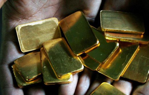 FILE PHOTO: A worker shows gold biscuits at a precious metals refinery in Mumbai