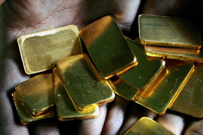 FILE PHOTO: A worker shows gold biscuits at a precious metals refinery in Mumbai