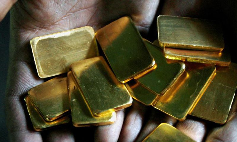 FILE PHOTO: A worker shows gold biscuits at a precious metals refinery in Mumbai