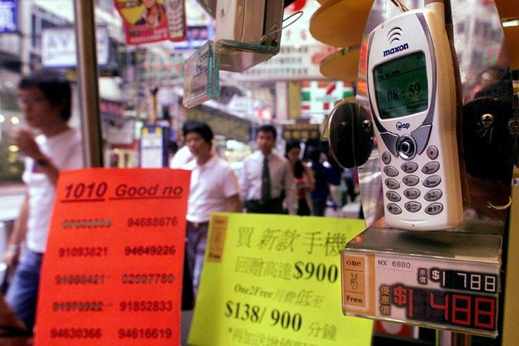 People walk past a mobile phone shop displaying lucky telephone numbers for sale in Hong Kong. Many Asian cultures consider certain numbers -- such as eight -- as good fortune