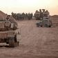 Israeli infantry soldiers gather next to tanks and an armoured personnel carrier near the Israeli border with the Gaza Strip on Sunday