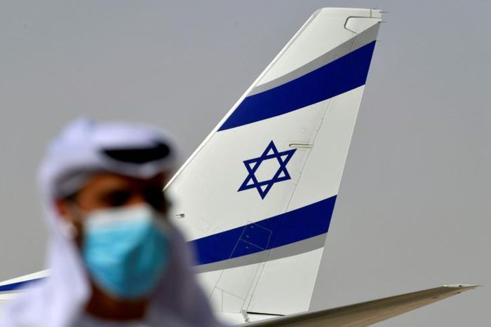 An Emirati official stands near the El Al aircraft which carried a US-Israeli delegation to the UAE on the first ever direct commercial flight following their normalisation accord