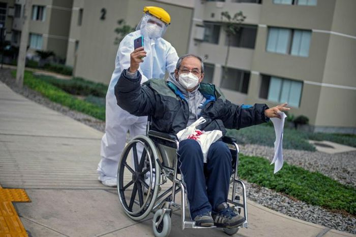 Cesar Sayan, 73, who has recovered from Covid-19, gestures as he leaves the temporary hospital set up in the former Athletes Village for the 2019 Pan American Games in Lima