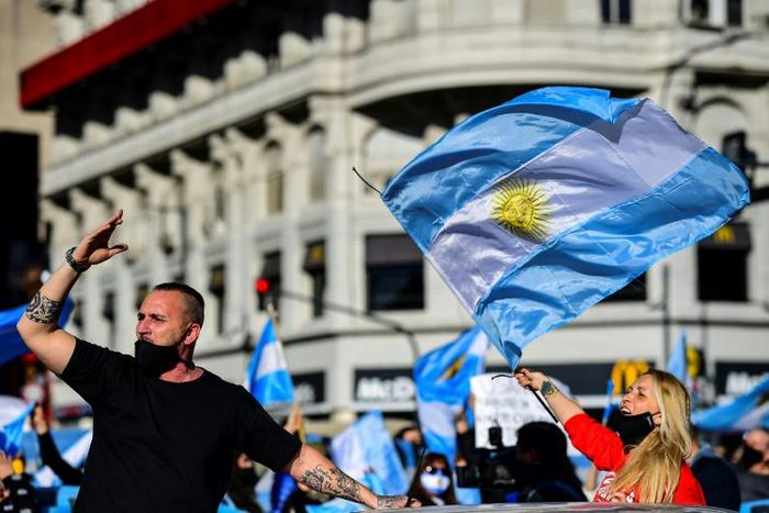 People wave Argentine flags during a protest in Buenos Aires against the government's tight lockdown measures against the spread of the novel COVID-19 coronavirus