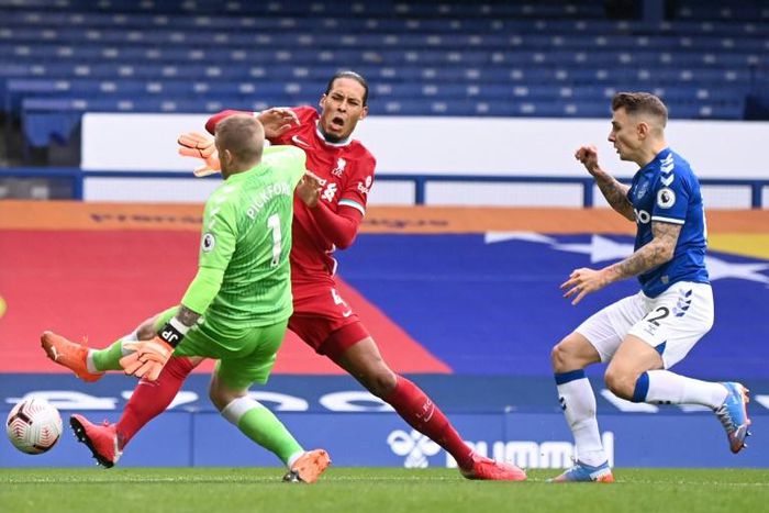 Everton goalkeeper Jordan Pickford tackles Liverpool defender Virgil van Dijk