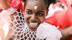 Adorned in colourful beads, a young woman is pictured in 2019 dancing before the Zulu king holding a long reed