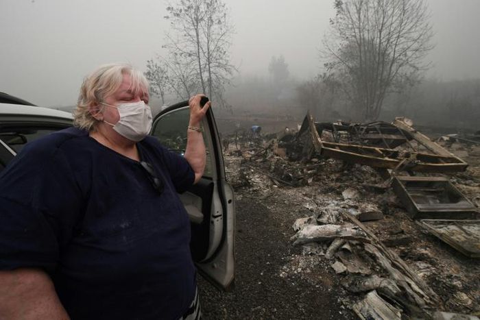 Margi Wyatt stands in front of her incinerated mobile home