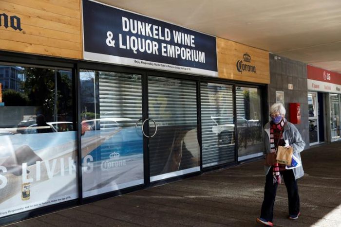 A woman walks past a closed liquor shop in Johannesburg in July 2020