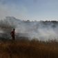 An Israeli firefighter extinguishes a fire close to the Gaza Strip caused by an incendiary balloon