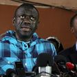 Opposition leader Kizza Besigye, left, speaking to the press after being bailed on treason charges in July 2016