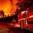 Butte County firefighters watch as flames tower over their truck at the Bear fire in Oroville, California