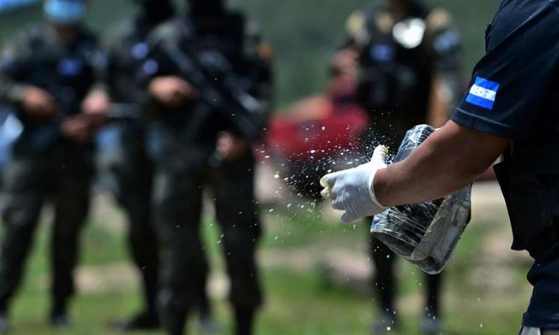 Members of Honduras's criminal investigation agency prepare to burn 250,000 kilograms of cocaine seized during the month of May 2020