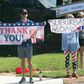 Supporters of Donald Trump and Joe Biden wave competing signs as the president's convoy arrives at a golf course in Sterling, Virginia, on August 23, 2020