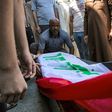 Mourners gather around the Iraqi flag draped coffin of slain activist Riham Yaaqub during her funeral in the city of Basra on Thursday