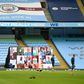 A screen displays images of fans in front of empty stands ahead of the Premier League match between Manchester City and Arsenal