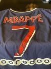 Kylian Mbappe presents jersey to Kurt Okraku