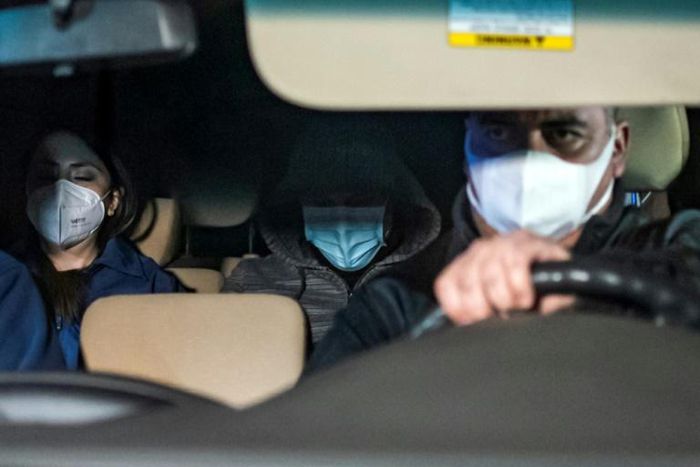 Police drive Nicolas Zepeda (C), suspected in the disappearance of a Japanese student in France in 2016, to the airport to be extradited to France