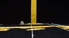 A Saudi workman adjusts the new kiswa, the gold-embroidered black cloth covering the Kaaba, that is changed during each year's hajj