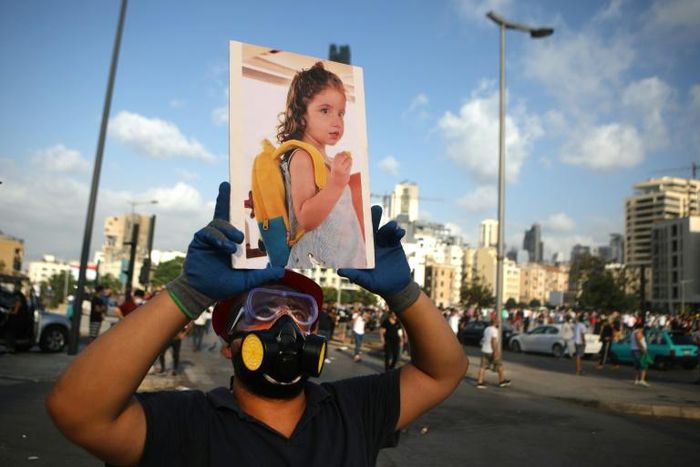 A Lebanese protester carries a photo of three-year-old Alexandra, who was fatally injured in the port explosion