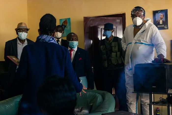 Zimbabwean journalist and documentary filmmaker Hopewell Chin'ono, right, as police searched his office in Harare on Monday