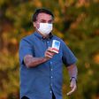 Brazilian President Jair Bolsonaro, seen here showing off a box of hydroxychloroquine to supporters outside presidential palace in Brasilia said nearly everyone will probably get the coronavirus, just like he did