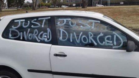 Man celebrates divorce by driving all over town in a car littered with "Just Divorced"