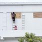 Workers board up the windows of a store in preparation for hurricane Nana in Belize City on Wednesday