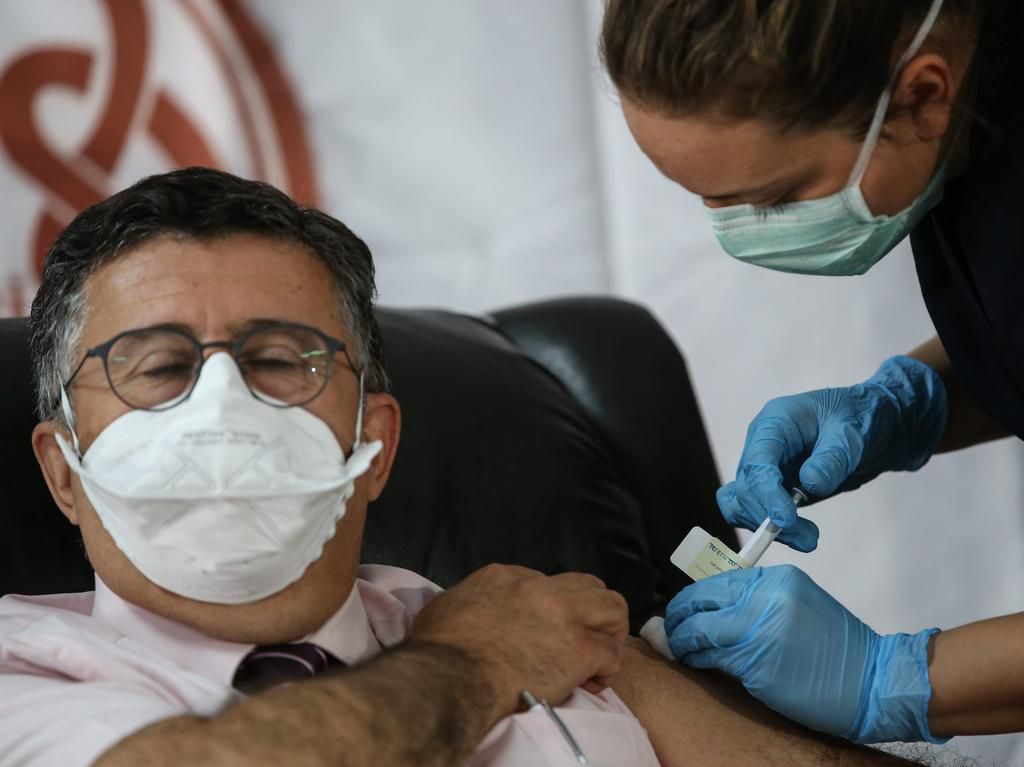 A health care worker injects a patient with a syringe of the phase 3 Pfizer and BioNTech vaccine trial in Turkey in October 2020.