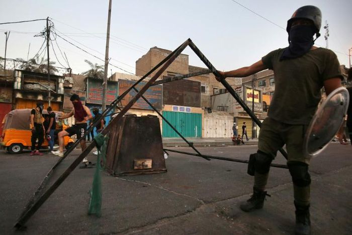 Iraqi protesters gather at a roadblock in al-Tayaran Square in central Baghdad during ongoing anti-government protests yet the premier announced a date for elections
