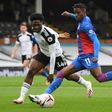 Fulham defender Ola Aina fails to prevent Crystal Palace winger Wilfried Zaha (R) unleashing a shot