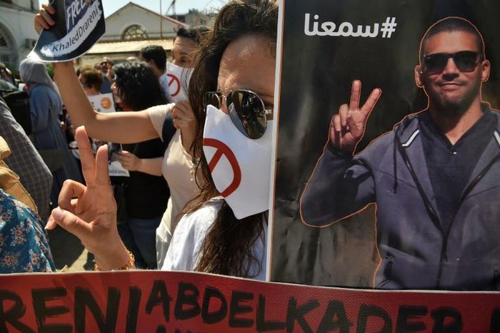 Algerians carry portraits of journalist Khaled Drareni during a rally to protest against his imprisonment in the capital Algiers on September 7